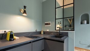 Une cuisine moderne avec des plans de travail sombres, un évier encastré et une fenêtre offrant une belle vue.