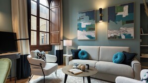 Un salon moderne avec un canapé, des fauteuils, une table basse et des œuvres d’art accrochées au mur.