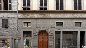 Un bâtiment doté d’une grande porte en bois, de nombreuses fenêtres et d’une vitrine avec des mannequins.