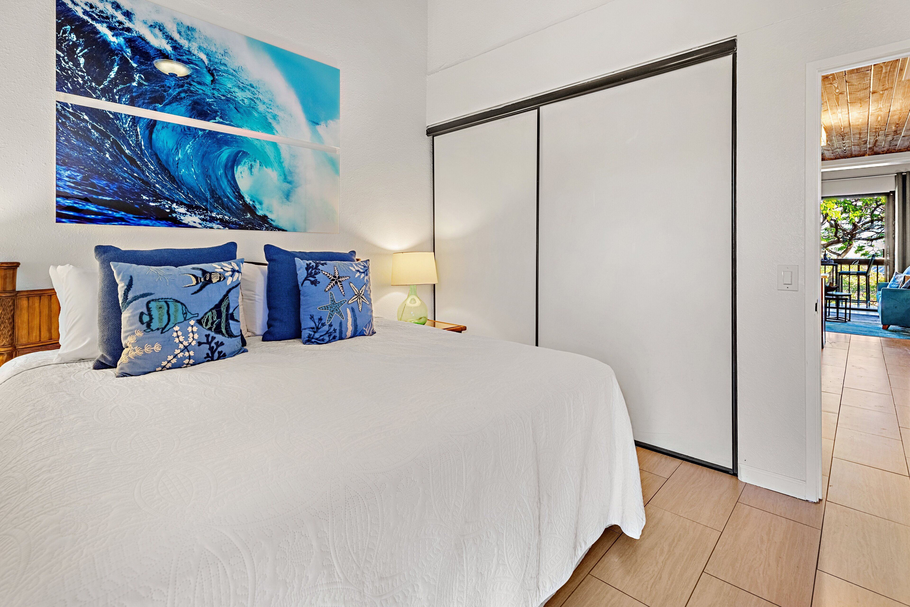 A bedroom with a large bed, a sliding door, and a view of the outdoors.