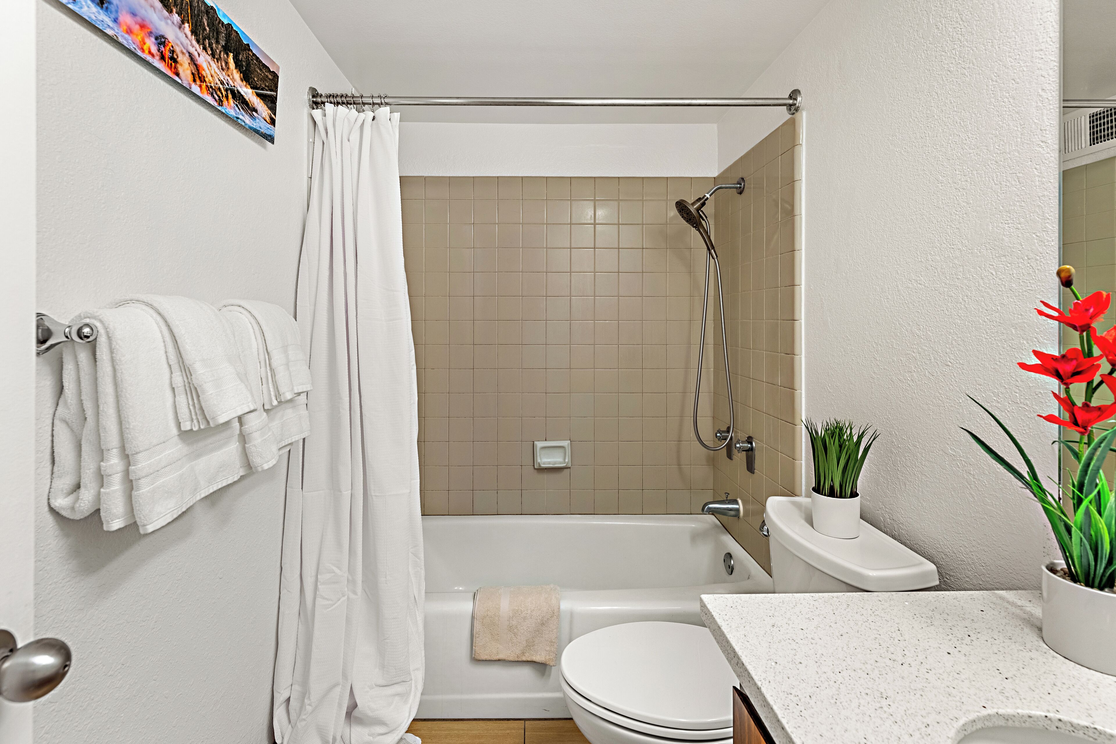 A bathroom with a bathtub, toilet, and sink.