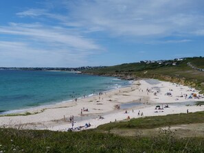 A beach with people sunbathing and swimming, houses in the background, and a clear sky. - 481-Fisherman's cottage, 180° sea view, near beaches. (Plouhinec)