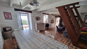 Une chambre avec un grand lit, une table en bois, une télévision et une chaise.