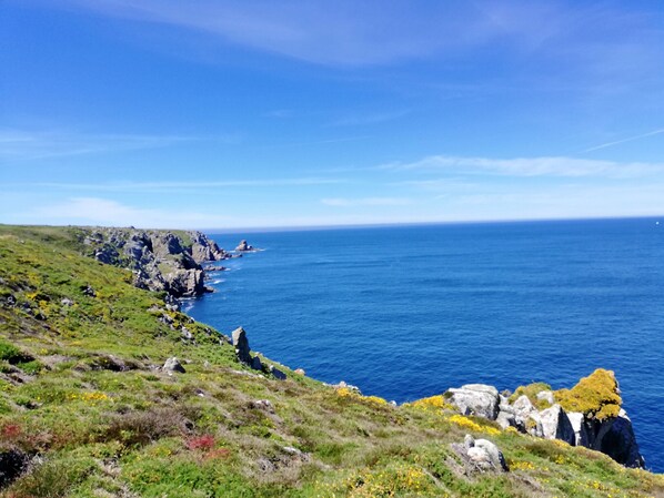 Un paysage côtier caractérisé par des falaises rocheuses et une mer d’un bleu limpide.