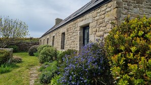 A stone building with a sloped roof and a small window.