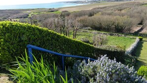 A landscaped garden with a hedge, a stone wall, and a view of the sea. - 622-Ker An Enez,sea view, the beach at the end of the garden (Esquibien)