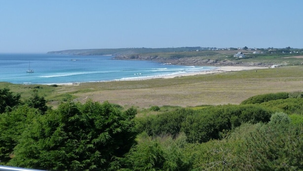 A coastal landscape with a view of the sea, grassy fields, and scattered buildings. - 622-Ker An Enez,sea view, the beach at the end of the garden (Esquibien)