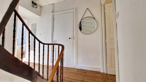 A staircase with wooden balusters leading to a white door.