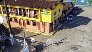 Un edificio con fachada amarilla y un cartel que dice "POUSADA MARAVISTA".