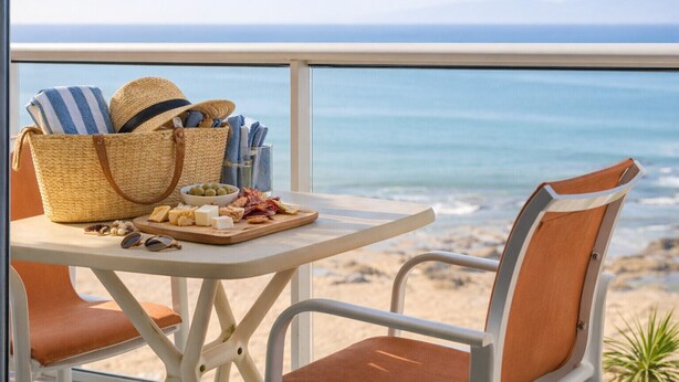 Une table avec un panier en osier, un bol d’olives et une planche de fromages et de charcuteries.