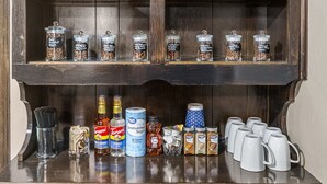 Eine Holztresne mit Kaffeebohnen in Gläsern, einer Kaffeemühle und einer Kaffeemaschine.