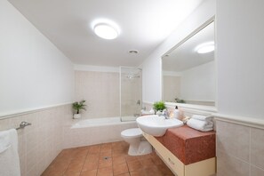 Un baño moderno con bañera, inodoro y lavamanos.