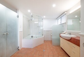 Ein modernes Badezimmer mit einer Duschkabine, einer Badewanne, einem Waschtisch und einem großen Spiegel.