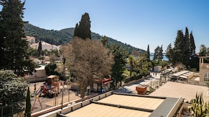 Ein Blick auf einen Park mit Spielgeräten, einem Kiosk und einem Gebäude mit rotem Dach.