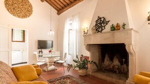 Un accogliente soggiorno con camino, zona pranzo e TV.