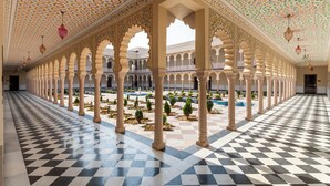 A spacious corridor with patterned flooring, ornate arches, and a checkered ceiling. - Kesarbagh Palace (Chittorgarh)