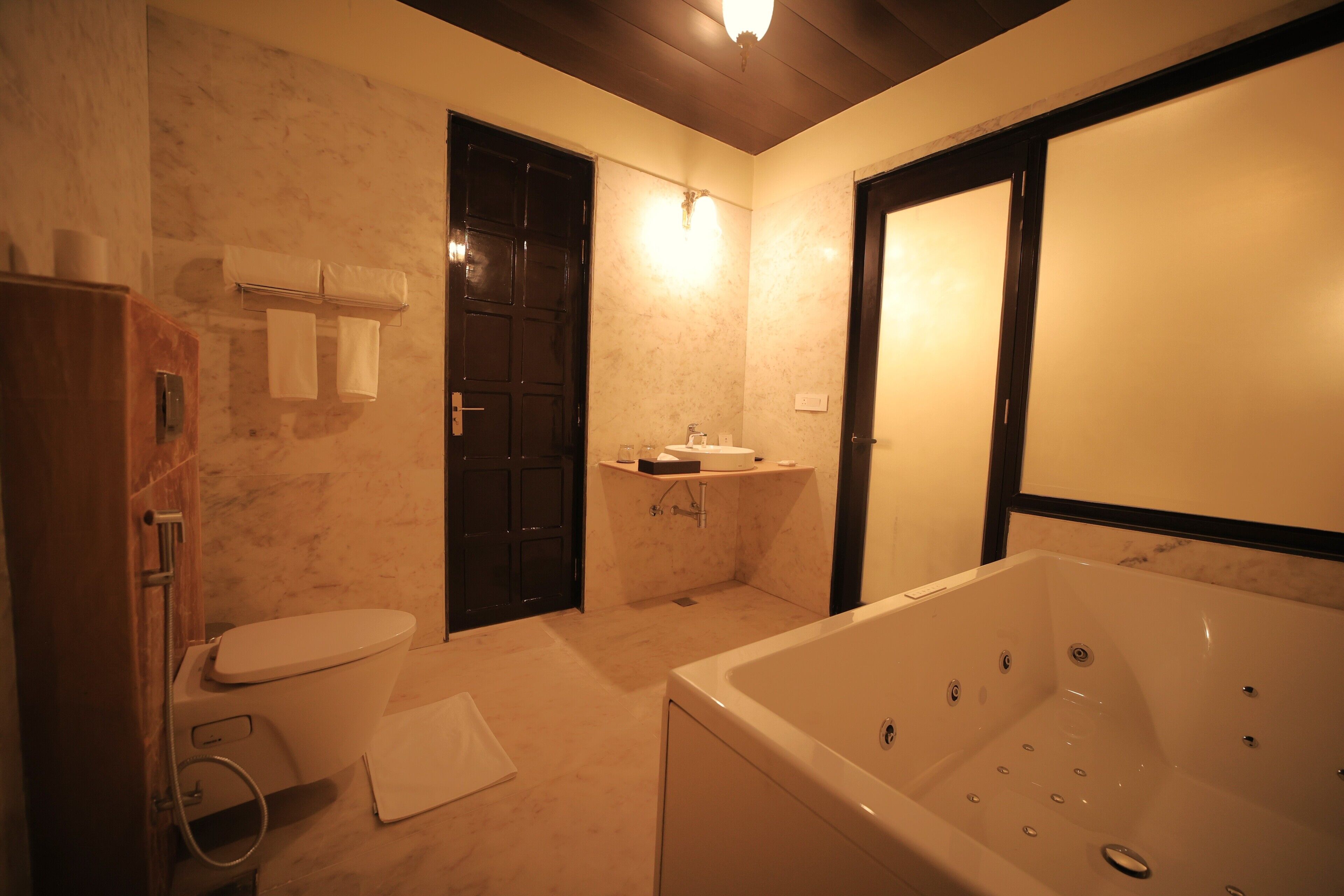 A bathroom with a toilet, sink, bathtub, and towel rack.