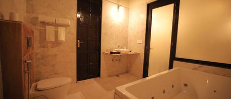 A bathroom with a toilet, sink, bathtub, and towel rack.