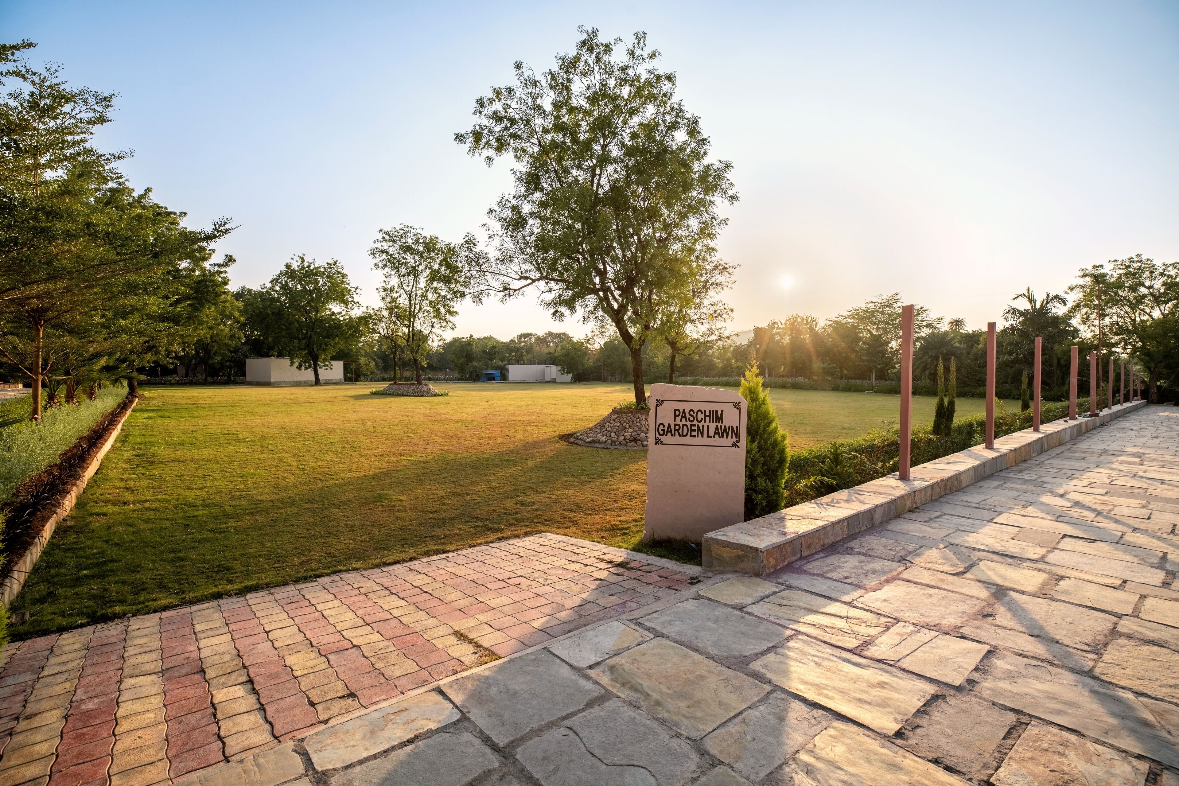 Placa para 'Paschim Garden Lawn', com um caminho pavimentado e área gramada.