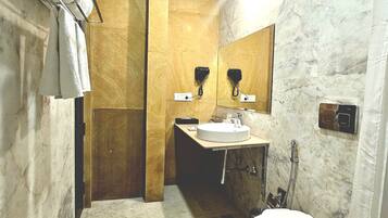 Un bagno con pavimento in marmo, un water, un lavandino e una doccia.
