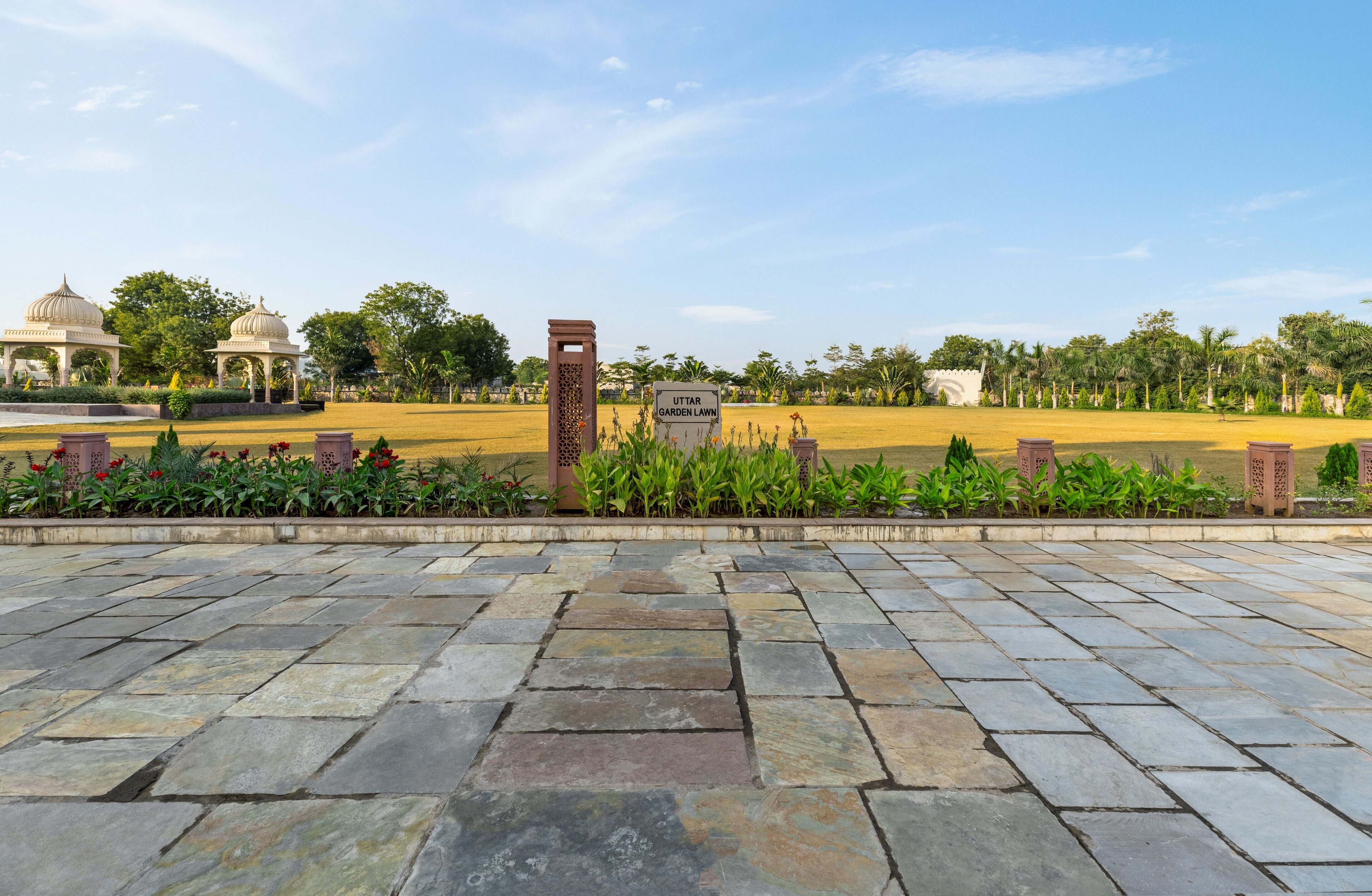 A stone-paved entrance to a garden lawn with a sign reading "UTTAR GARDEN LAWN".