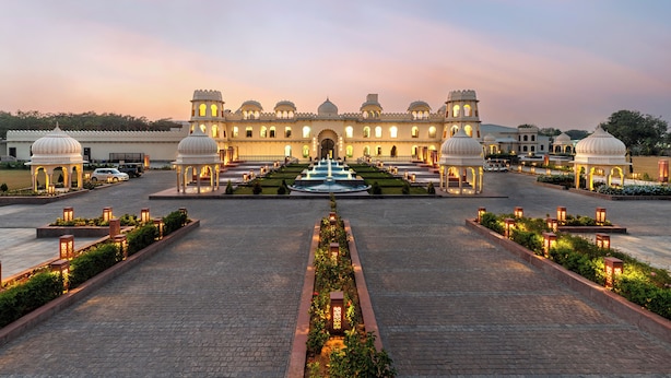 A grand hotel with a central fountain, symmetrical gardens, and traditional architecture. - Kesarbagh Palace (Chittorgarh)