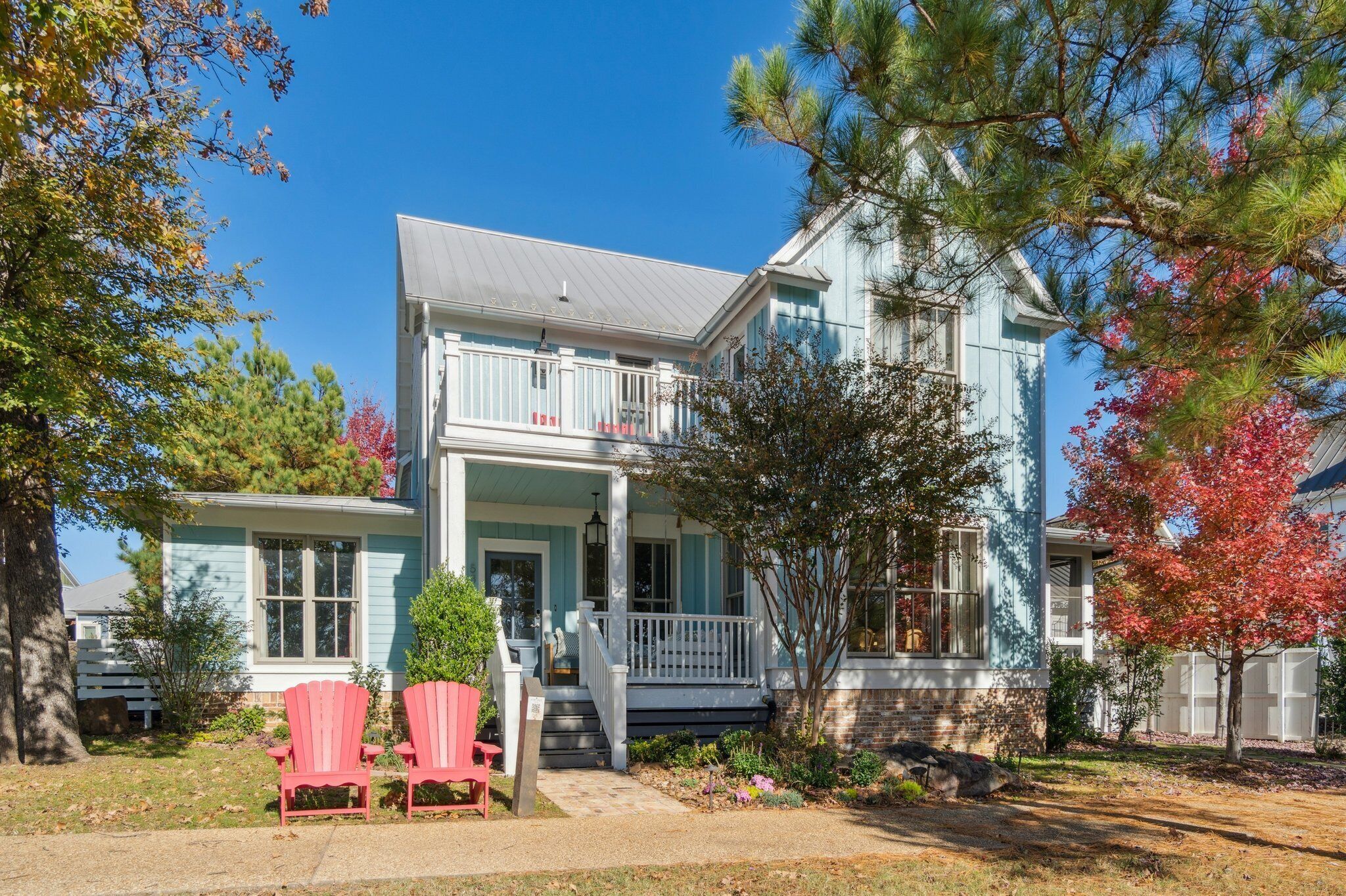 A two-story house with a porch, a covered front entrance, and a small front yard.