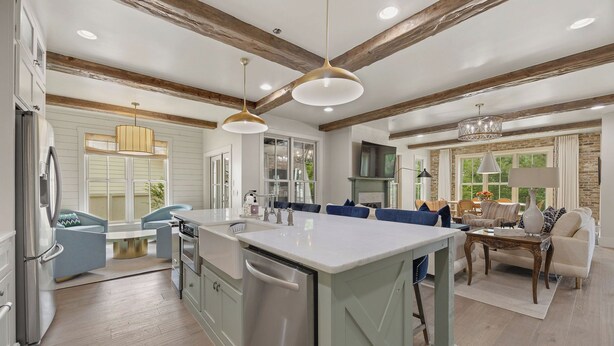A modern kitchen with a central island, built-in appliances, and a dining area with a large window.