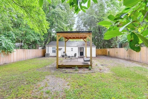 A wooden deck with a pergola, surrounded by a wooden fence, and a house in the background. - Serene Charleston Home Near Airport: Pets Welcome! (North Charleston)