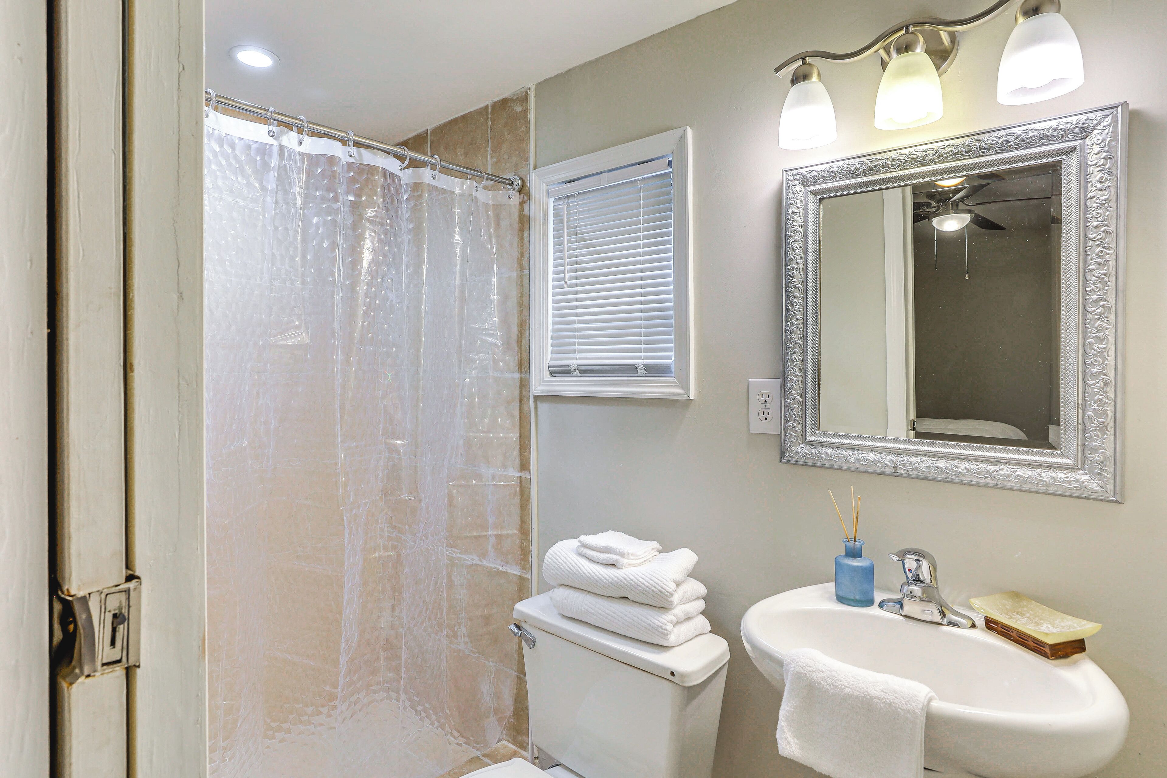 Un bagno con doccia, servizi igienici, lavandino e specchio.