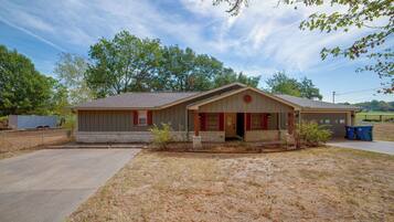 A single-story house with a front porch, a garage, and a small yard.