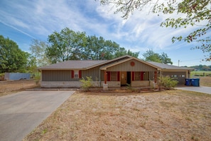 A single-story house with a front porch, a garage, and a small yard. - Yard, Deck & Fire Pit: Cedar Creek Reservoir Gem (Mabank)