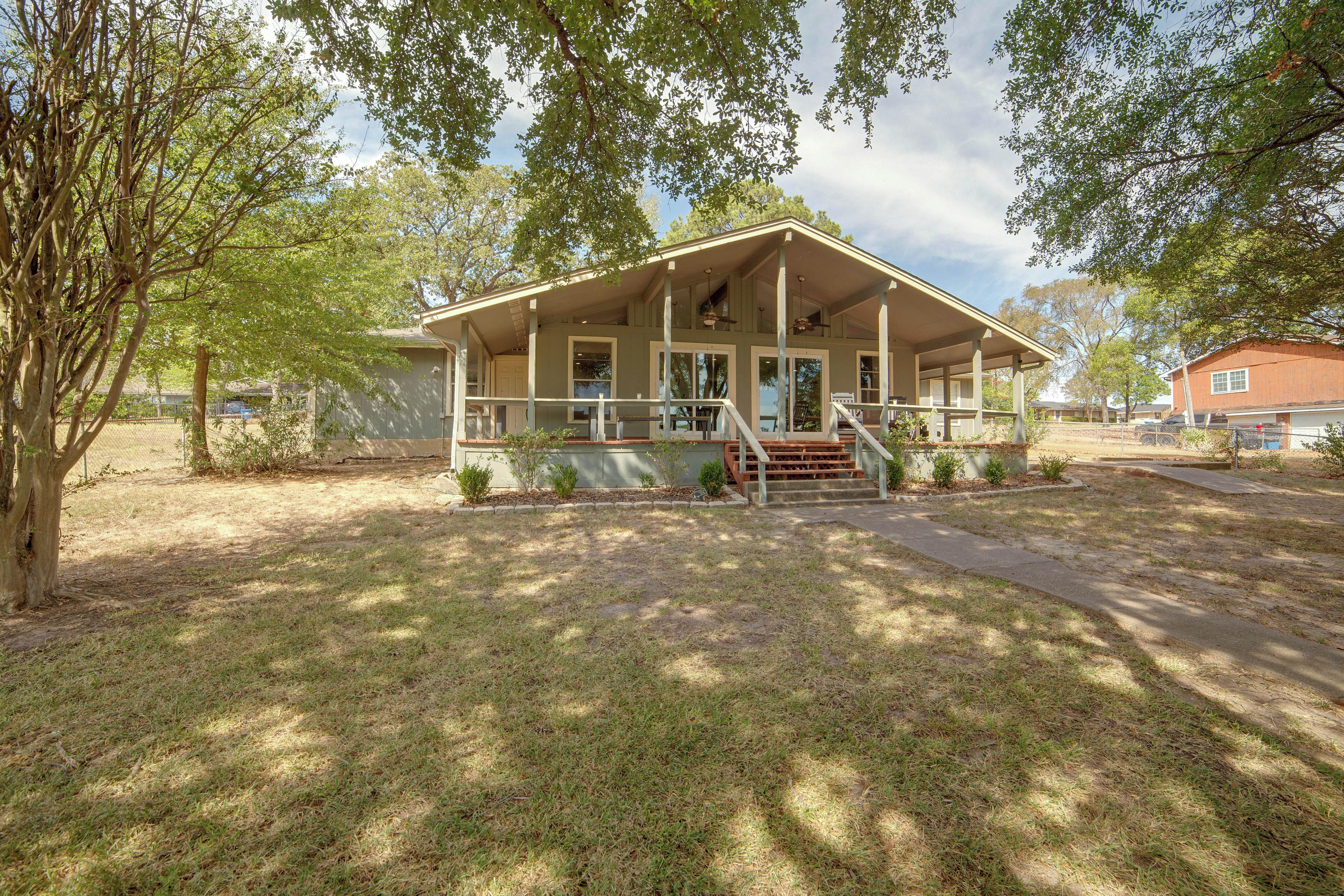 A two-story house with a porch, a front door, and a staircase leading to the entrance.