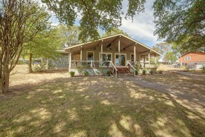 A two-story house with a porch, a front door, and a staircase leading to the entrance. - Yard, Deck & Fire Pit: Cedar Creek Reservoir Gem (Mabank)