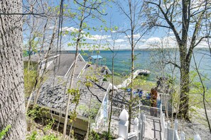 A lakeside property with a wooden deck, a white fence, and a boat dock. - Waterfront Romulus Getaway w/ Private Dock! (Romulus)