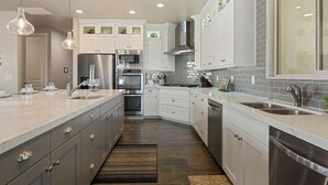 A modern kitchen with white cabinetry, stainless steel appliances, and pendant lighting. - Great Escape #63: Private Hot Tub, Paradise Village Waterpark + Pools, Home Thea (Santa Clara)