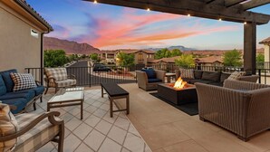An outdoor patio with furniture, a fire pit, and a view of a residential area with houses and mountains. - Great Escape #63: Private Hot Tub, Paradise Village Waterpark + Pools, Home Thea (Santa Clara)