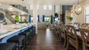 A spacious kitchen with a central island, bar stools, and a dining area with wooden chairs. - Great Escape #63: Private Hot Tub, Paradise Village Waterpark + Pools, Home Thea (Santa Clara)