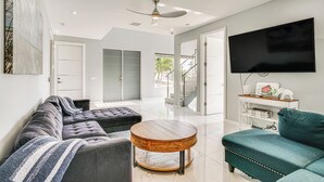 Un salon moderne avec un canapé, un pouf et une table basse ronde.