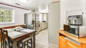 A compact kitchen with a microwave, refrigerator, and wooden dining table with chairs. - Seneca Vacation Rental w/ Grill Near Lake Hartwell (Seneca)