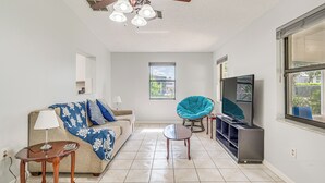 A living room with a ceiling fan, a TV, a sofa, a chair, and a small table. - 5 Mi to Weeki Wachee! Home w/ Lanai & Air Hockey (Spring Hill)