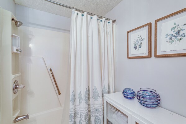 A bathroom with a shower curtain, framed artwork, and decorative vases on a shelf. - 2 Mi to Ski Resort! Sugar Mtn Condo w/ Indoor Pool (Banner Elk)