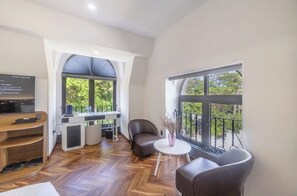 Habitación doble Deluxe | Área de sala de estar | Televisión 