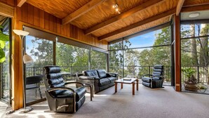 A spacious room with leather furniture, large windows, and a wooden ceiling. - Anchorage Views: Indulge in the ultimate coastal getaway at Anchorage Views (Metung)