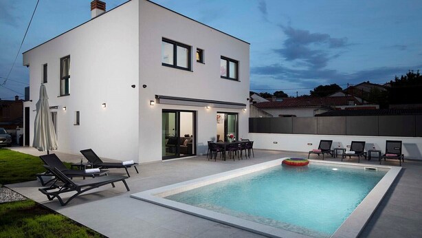 A modern two-story house with a swimming pool, outdoor seating, and a covered patio area. - Villa Rudina, a luxurious villa near the beach (Pomer)