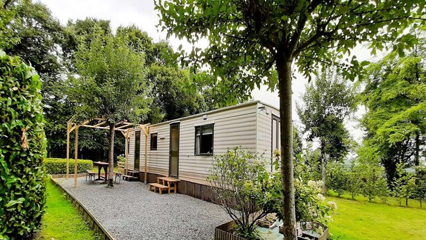 A mobile home with a patio area, a wooden pergola, and a small garden. - Tour de France Retreat (Gouvets)
