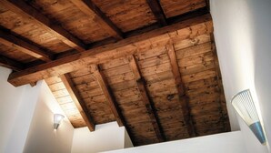 A wooden ceiling with exposed beams and a slanted roofline. - Lake Nest (Carate Urio)