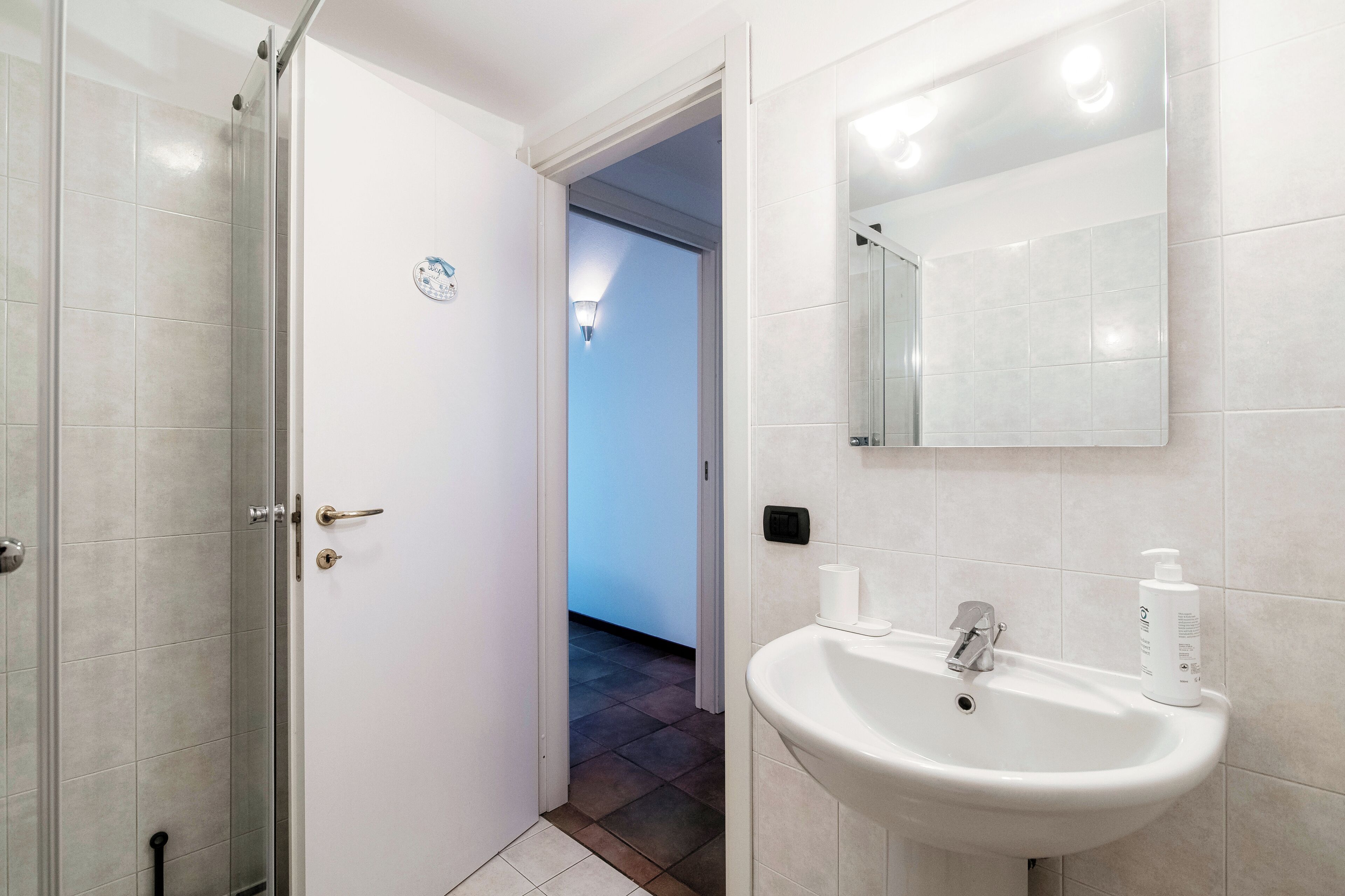 A bathroom with a shower, sink, and mirror.