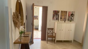 Ein Flur mit einer hölzernen Bank, einem weißen Schrank und Bildern an der Wand.