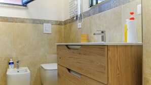 Ein Badezimmer mit Toilette, Waschbecken und Spiegel.